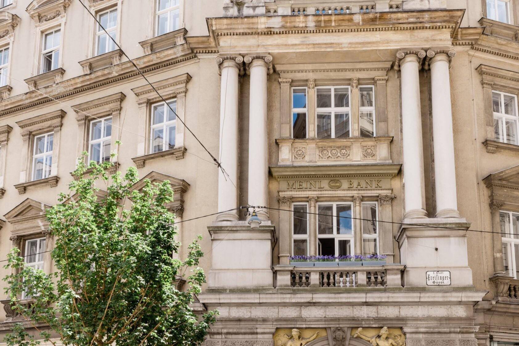 Historisches Gebäude mit klassischer Architektur, Säulen, Balkonen und der Aufschrift 'Meinl Bank'.