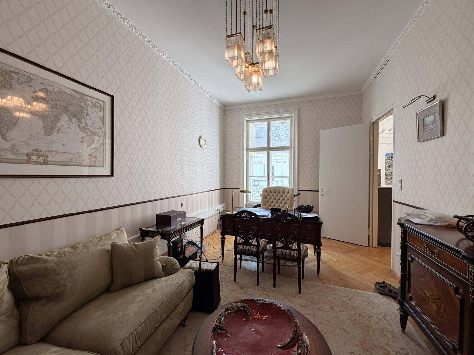 Klassisches Büro mit Schreibtisch, Sofa und einem Fenster, das viel natürliches Licht hereinlässt.