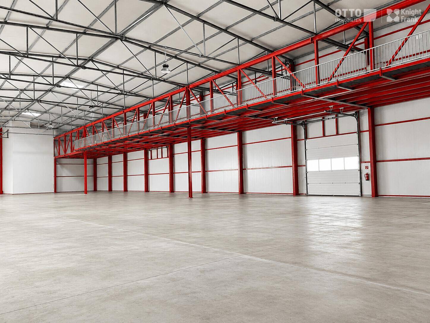 Geräumige Lagerhalle mit roter Stahlkonstruktion, Betonboden und einem großen Rolltor.
