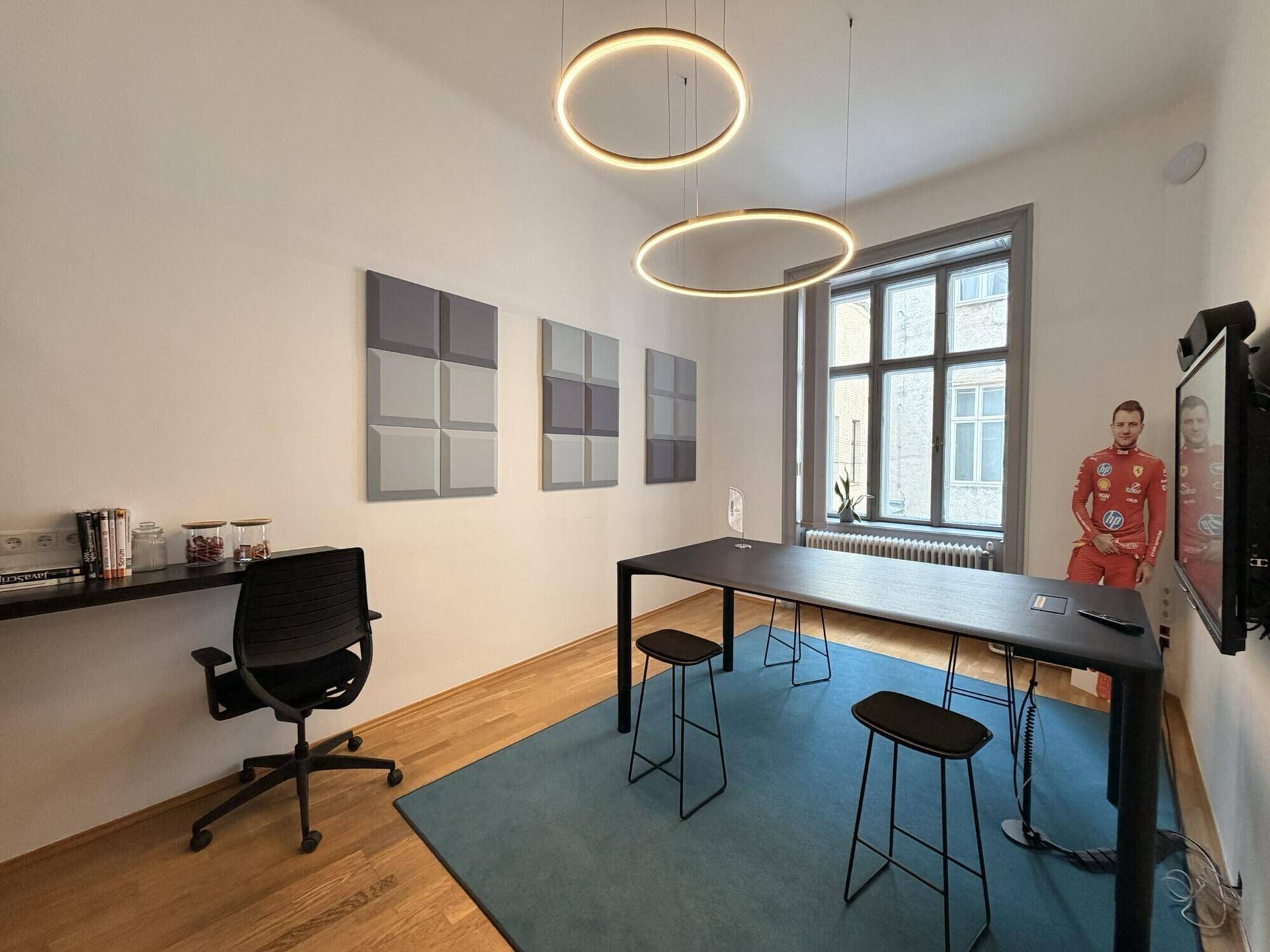 Modernes Besprechungszimmer mit Stehtisch, Barhockern und dekorativen Akustikpaneelen an der Wand.
