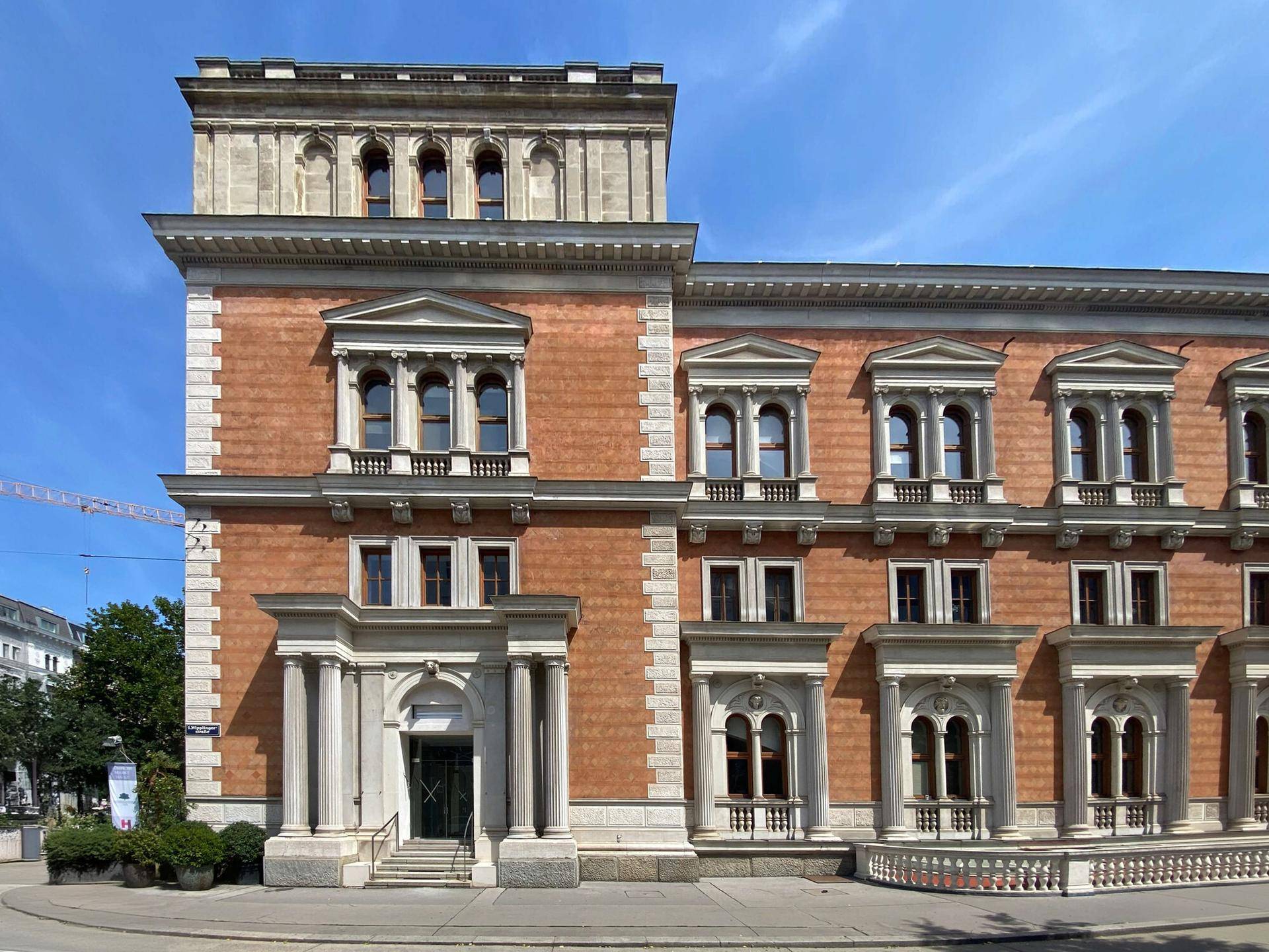 Prächtiges historisches Gebäude mit roter Fassade, weißen Verzierungen und einem markanten Turm.