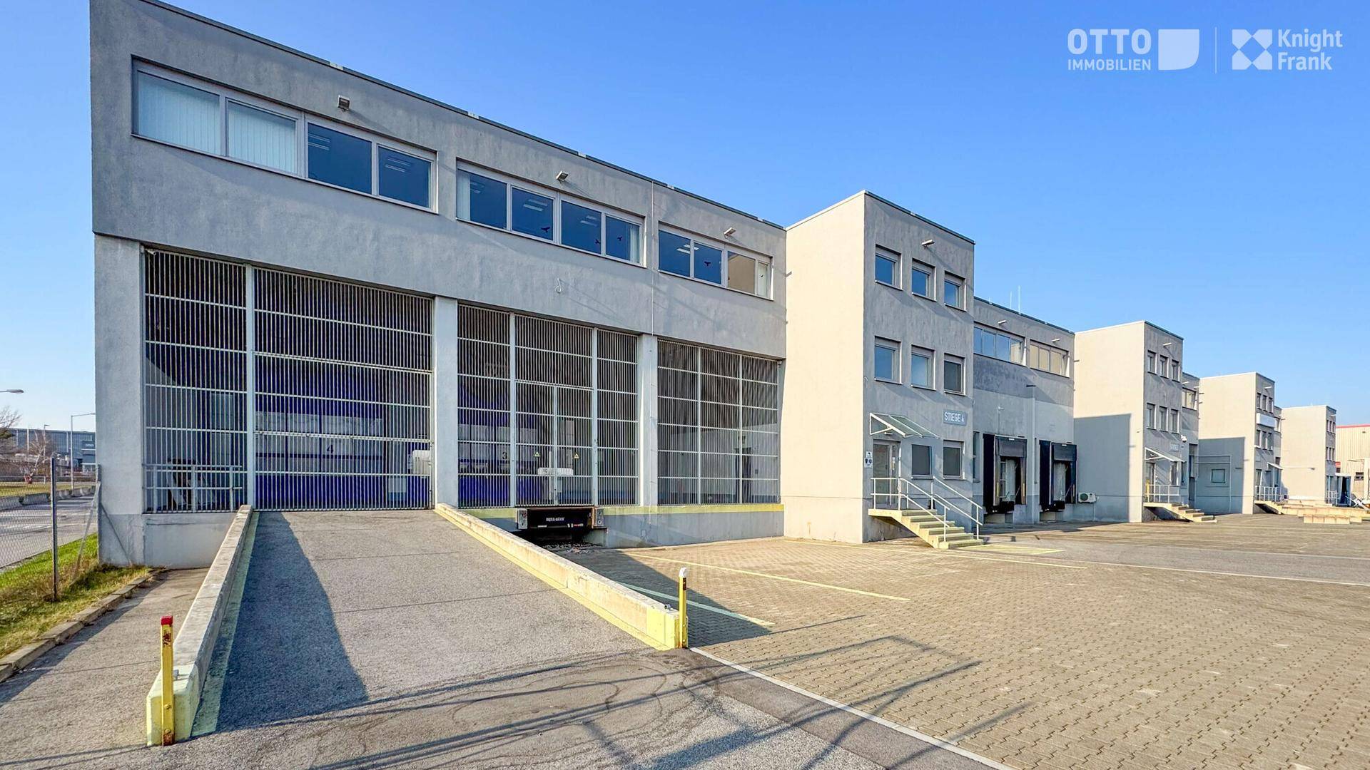Gesamtansicht des modernen Industrie- und Bürokomplexes mit Zufahrtsrampen und Parkplätzen.