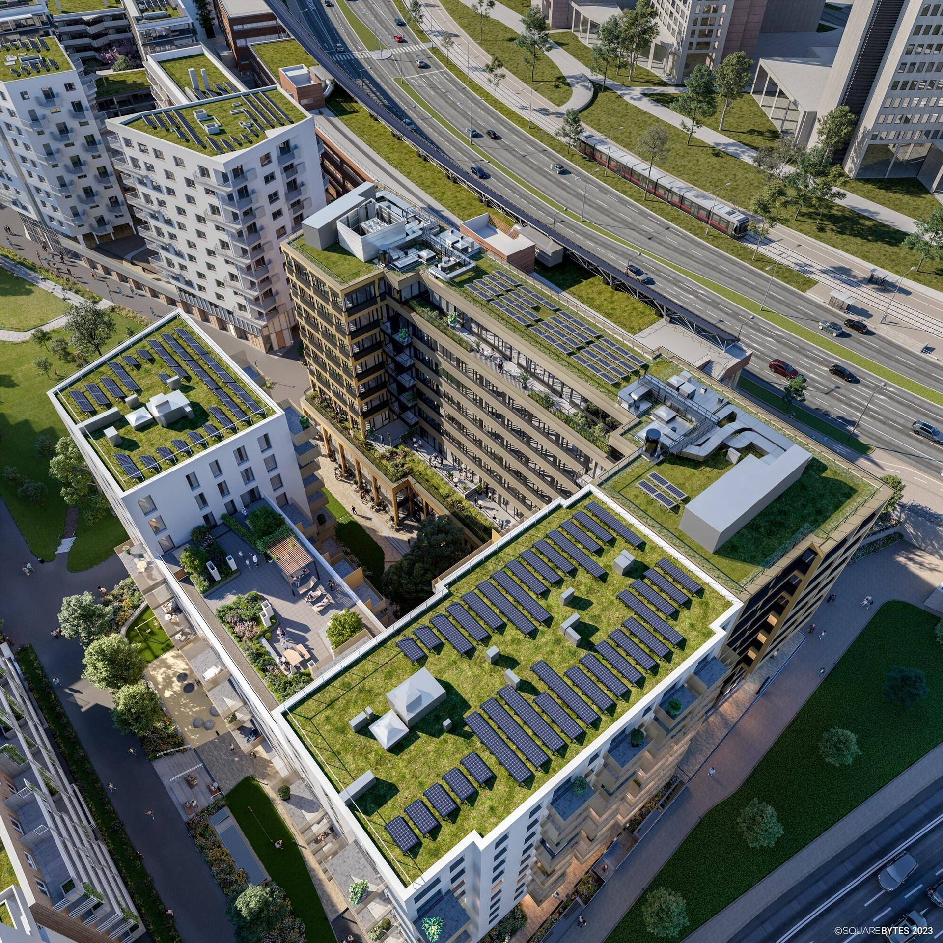 Luftaufnahme eines modernen Gebäudekomplexes mit begrünten Dächern und zahlreichen Photovoltaikanlagen.
