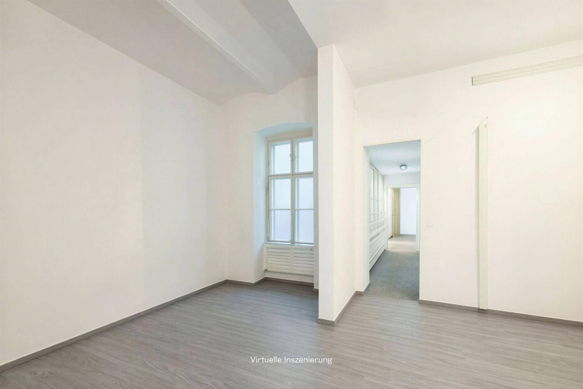 Heller Raum mit einem Fenster und Blick in einen langen Flur, ausgestattet mit Laminatboden.