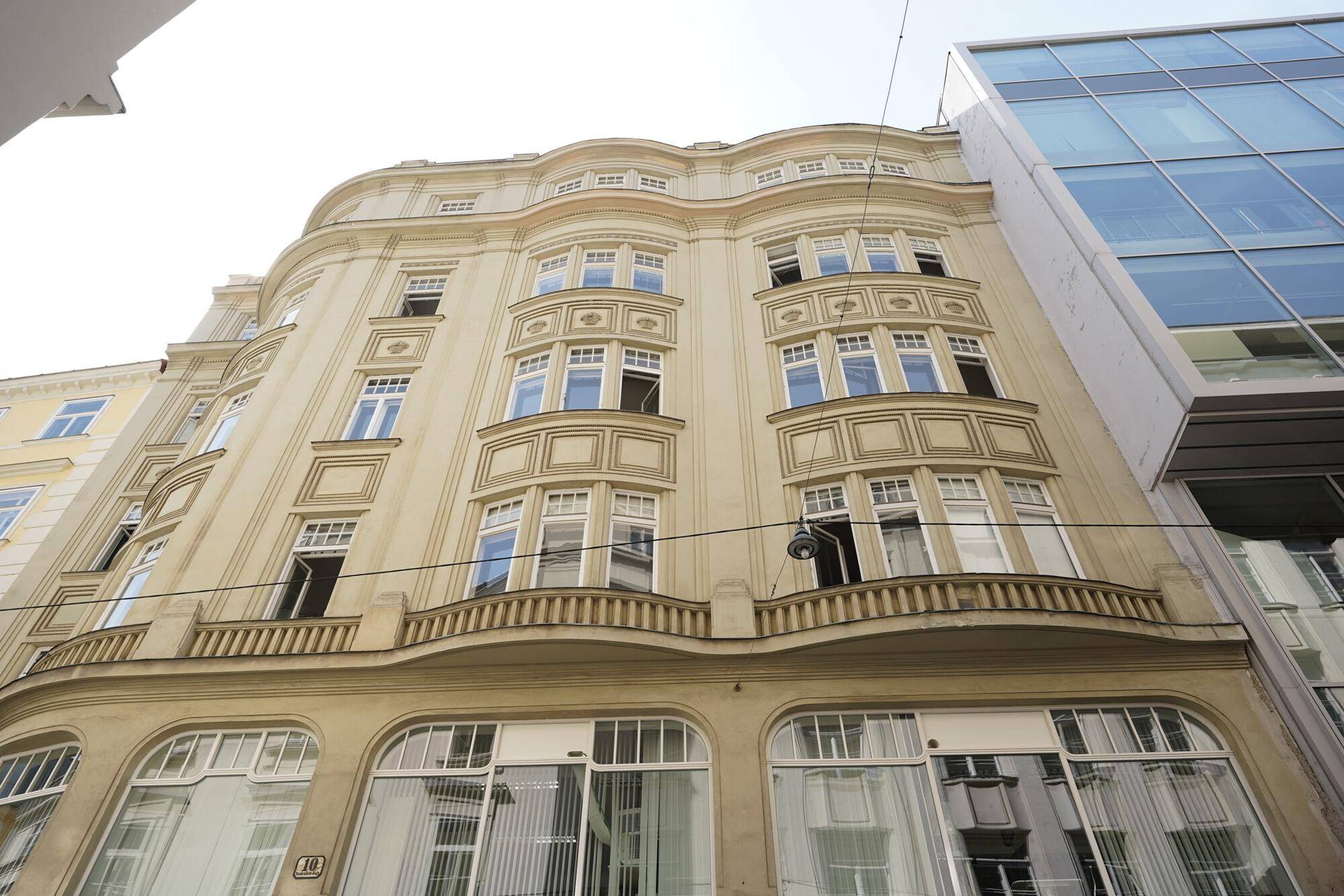Historisches Gebäude mit reich verzierter Fassade und vielen Fenstern in urbaner Umgebung.