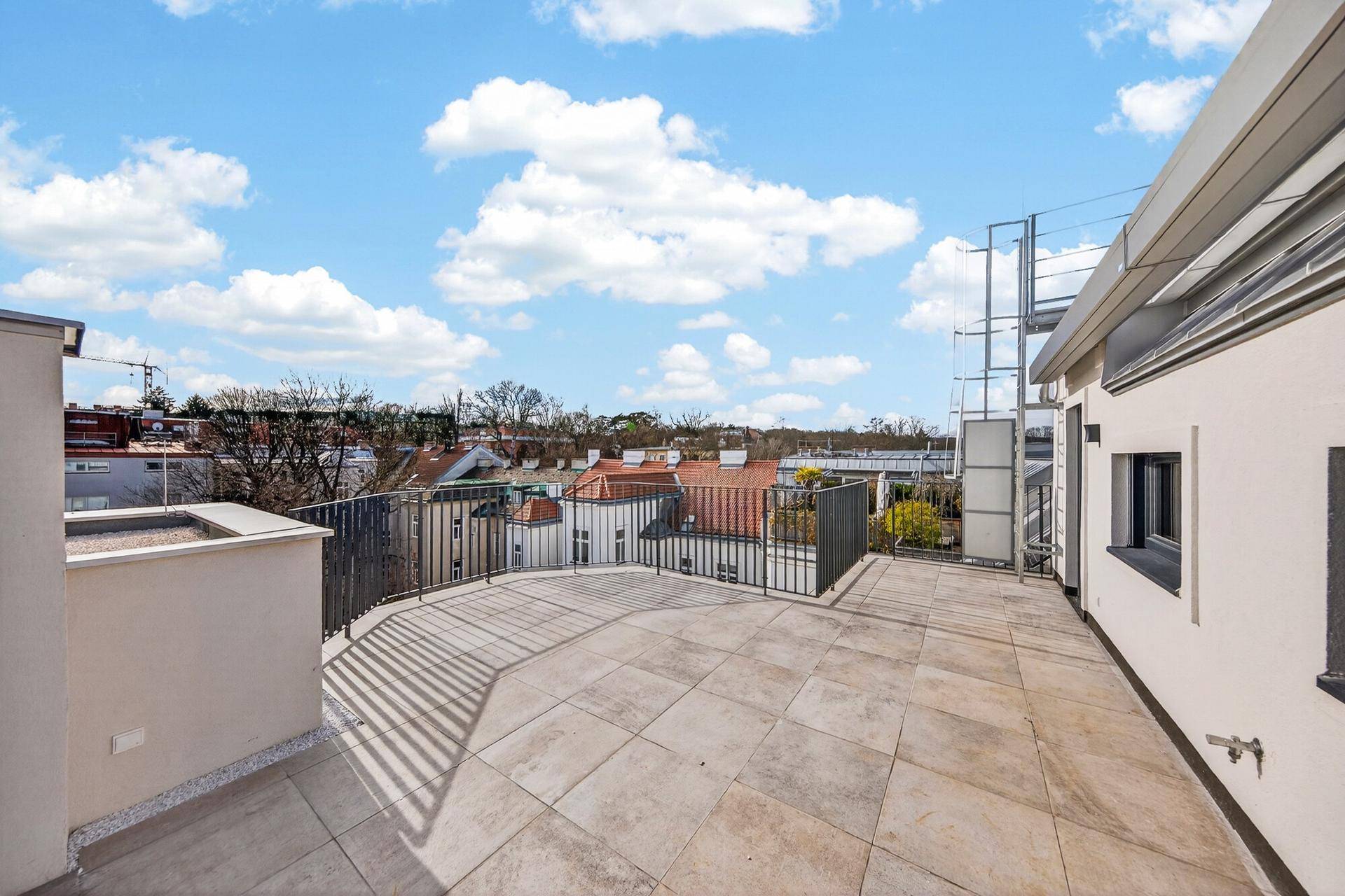 Weitläufige, geflieste Dachterrasse mit Panoramablick über die Stadt und viel Platz im Freien.
