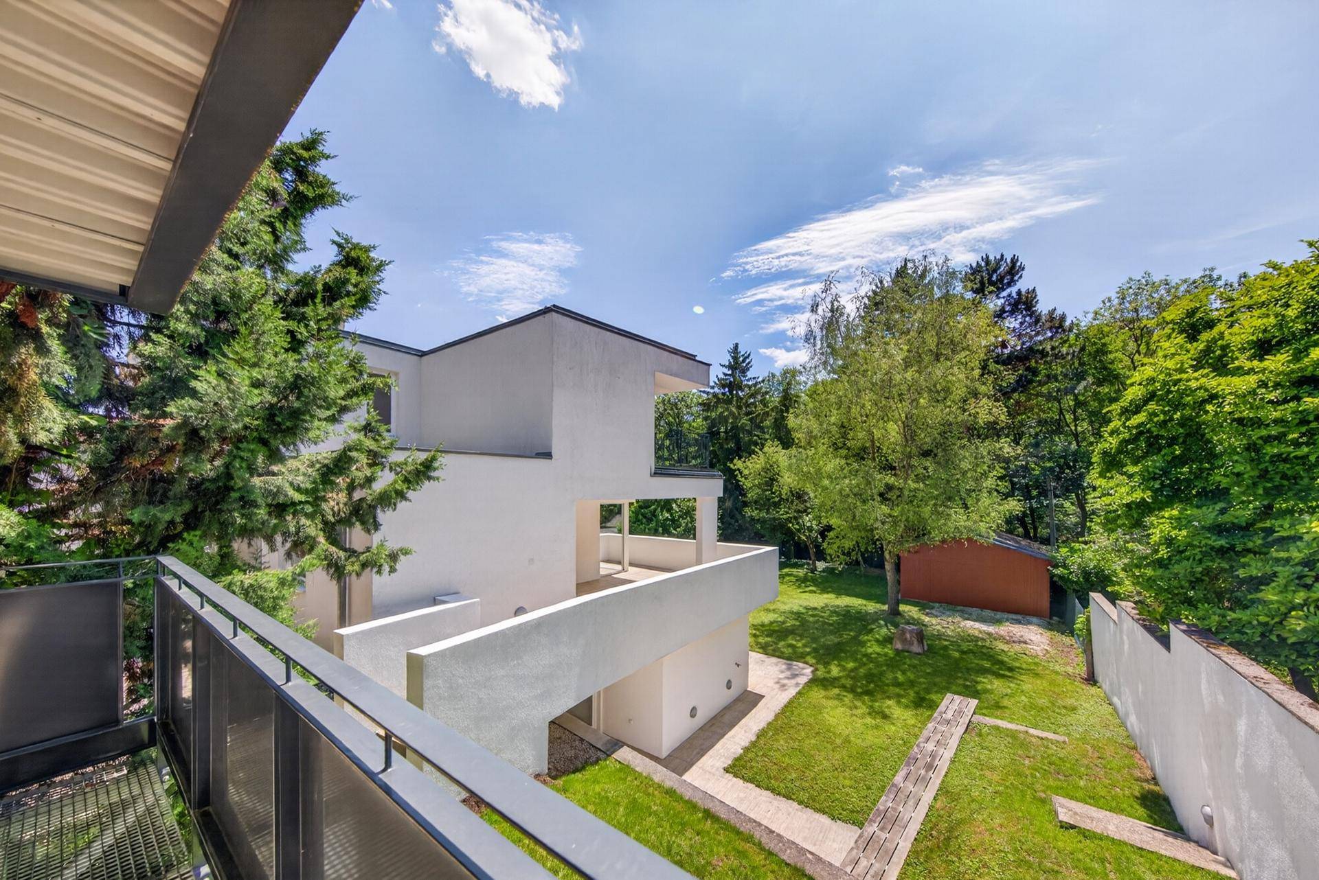 Blick von oben auf die moderne Architektur des Hauses mit Garten und umliegenden Bäumen.