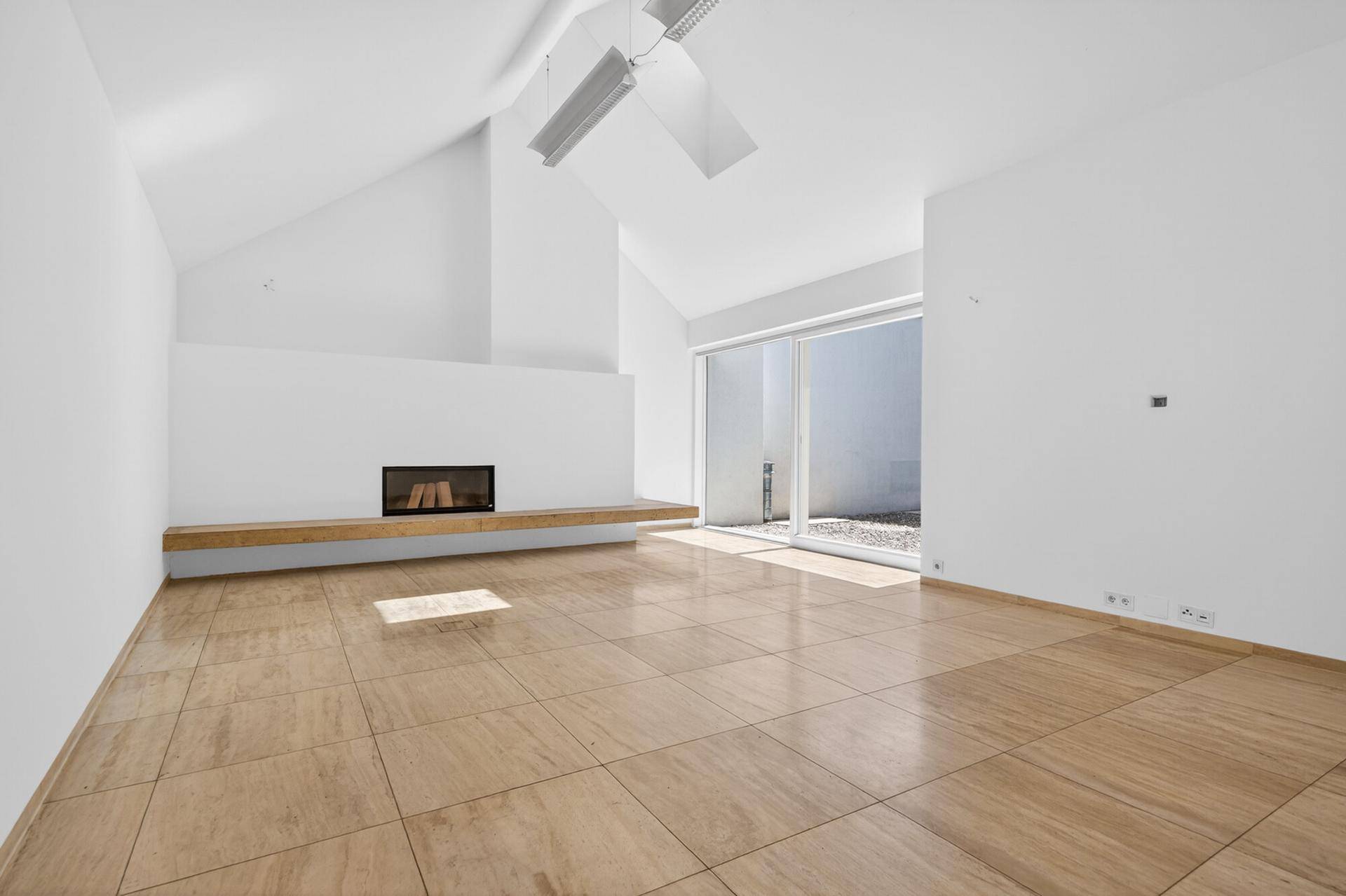 Helles Wohnzimmer mit hohen Decken, modernem Kamin und großformatigen Fliesenboden.