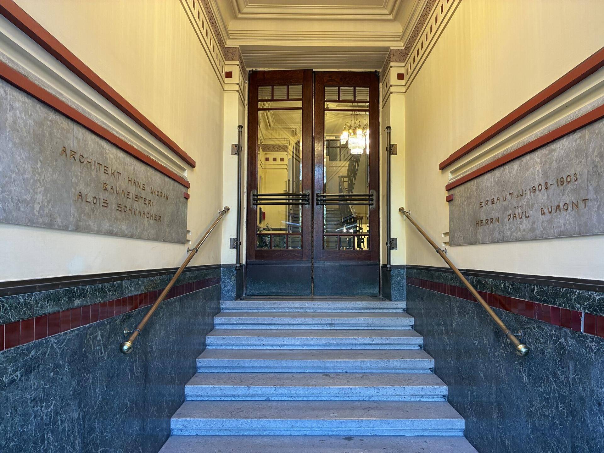 Repräsentativer Eingangsbereich eines Altbaus mit Marmorverkleidung und Treppe.