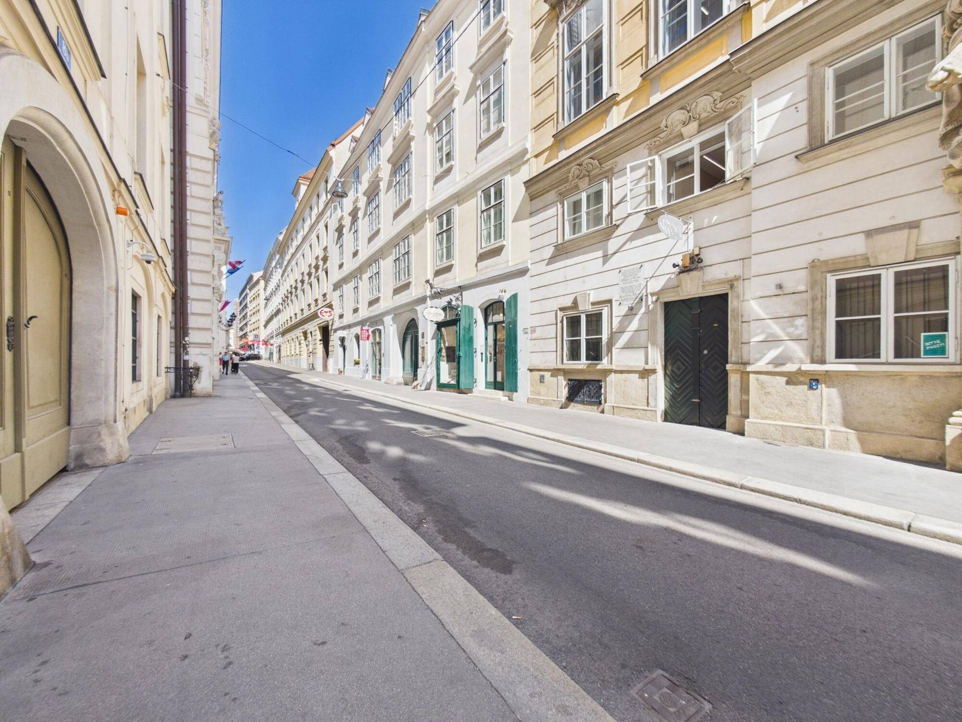 Historische Stadtstraße mit charmanten Gebäudefassaden unter blauem Himmel.
