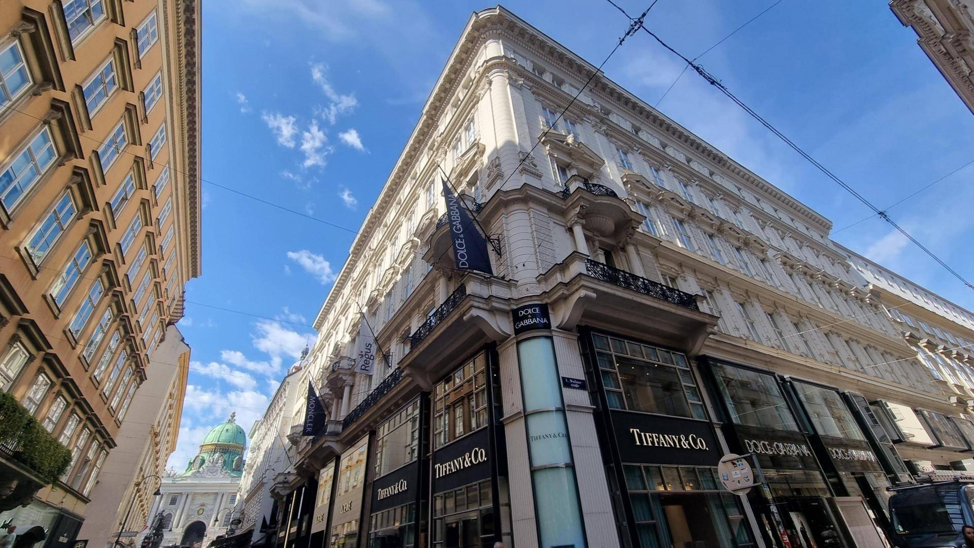 Prachtvolle Fassade eines historischen Gebäudes mit luxuriösen Geschäften im Erdgeschoss.