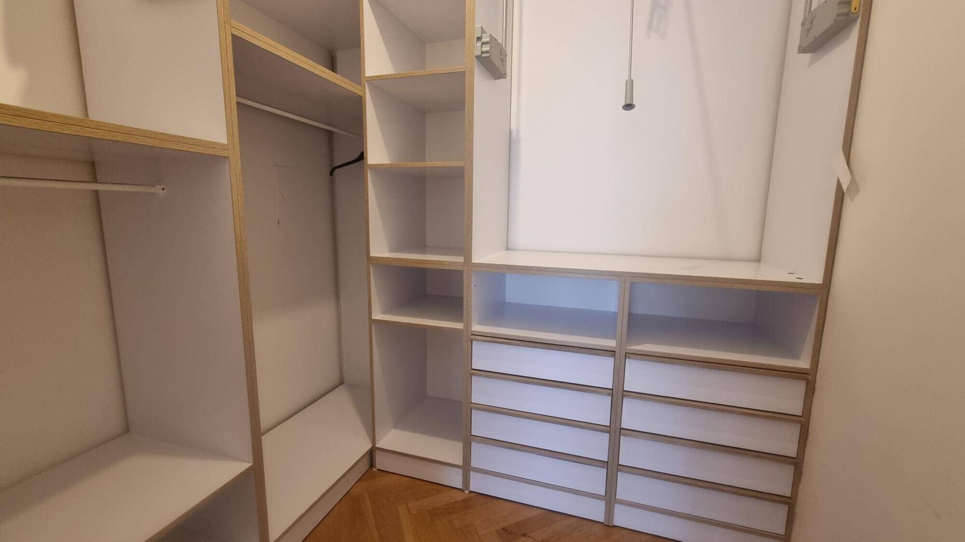 Begehbarer Kleiderschrank mit maßgefertigten Regalen und Schubladen für optimale Organisation.