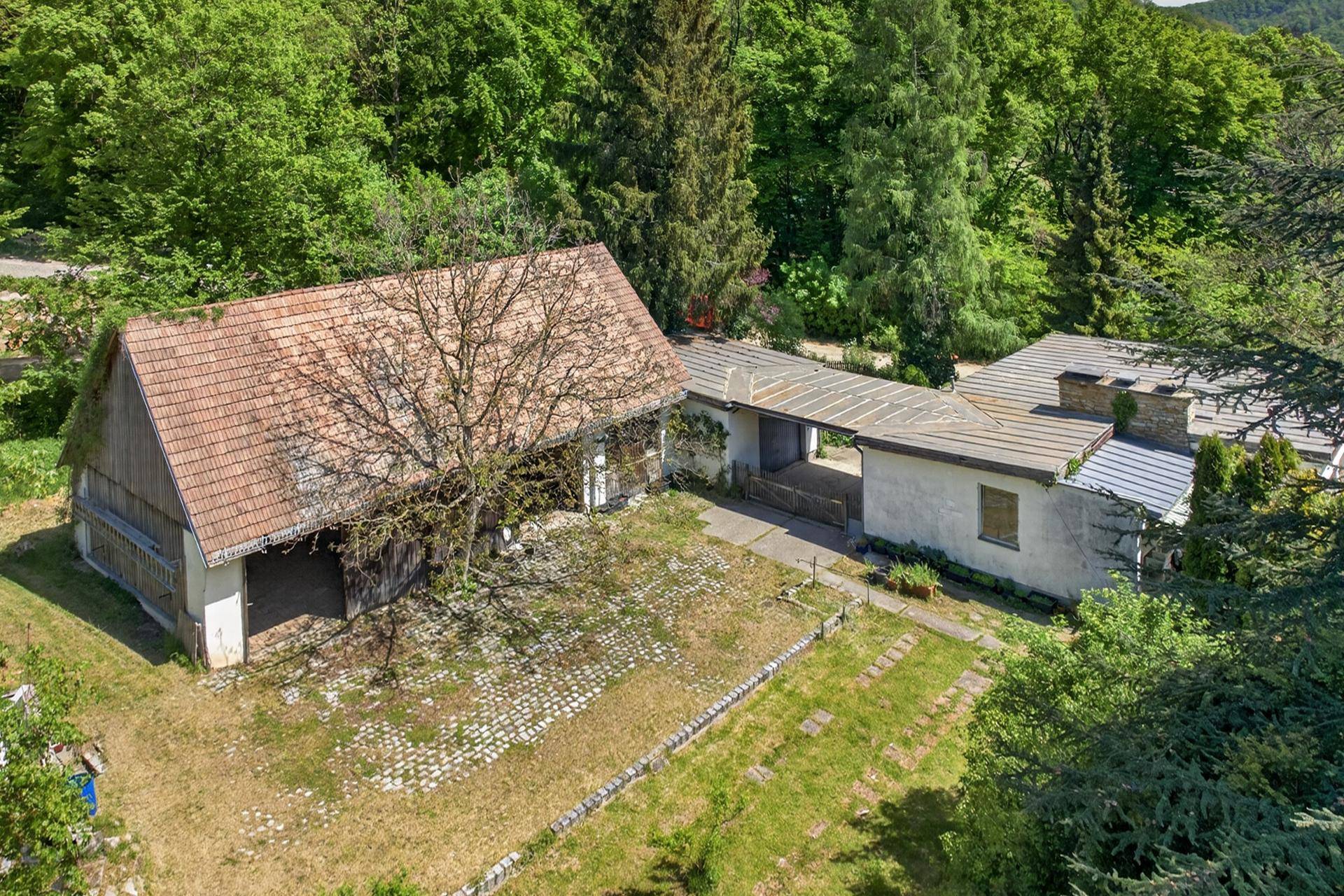 Luftaufnahme des Anwesens mit Haupthaus, Nebengebäude und weitläufigem Gartenbereich.