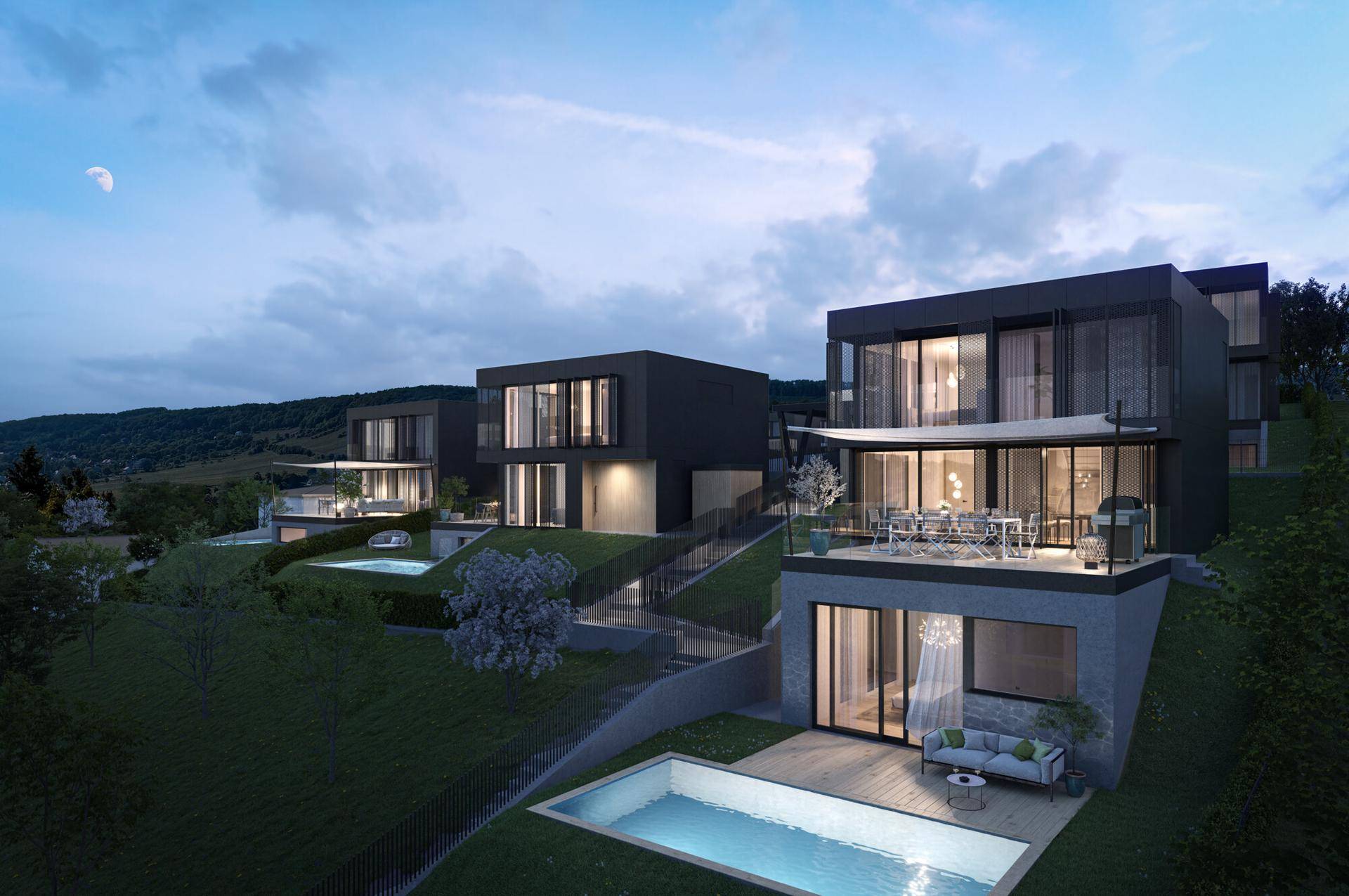 Moderne Villen auf einem grünen Hügel mit Pools und weitem Blick auf die Landschaft bei Dämmerung.