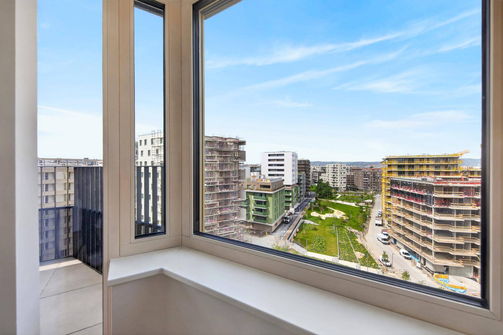 Raum mit großen Eckfenstern, die einen weiten Blick auf die umliegende Stadt bieten.