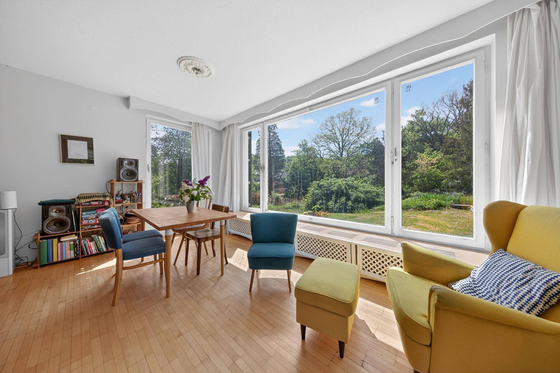 Heller Essbereich mit Holztisch, modernen Stühlen und weitem Blick in den Garten.