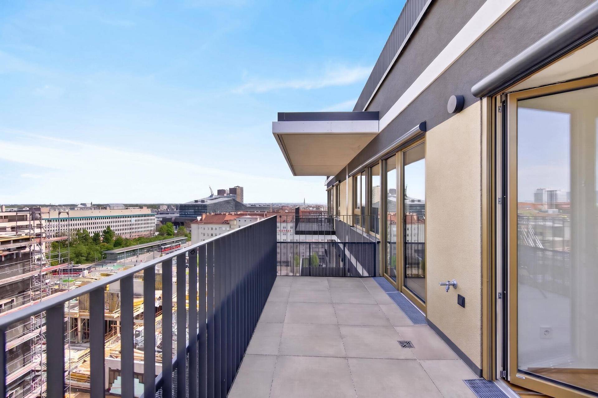 Geräumiger Balkon mit Fliesenboden und weitem Blick über die Stadtlandschaft.