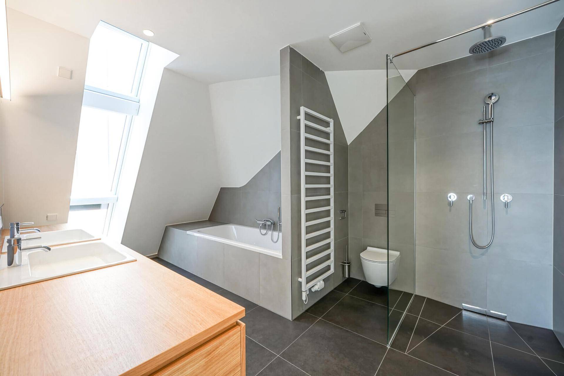Geräumiges, modernes Badezimmer mit Badewanne, begehbarer Dusche und beheiztem Handtuchhalter.