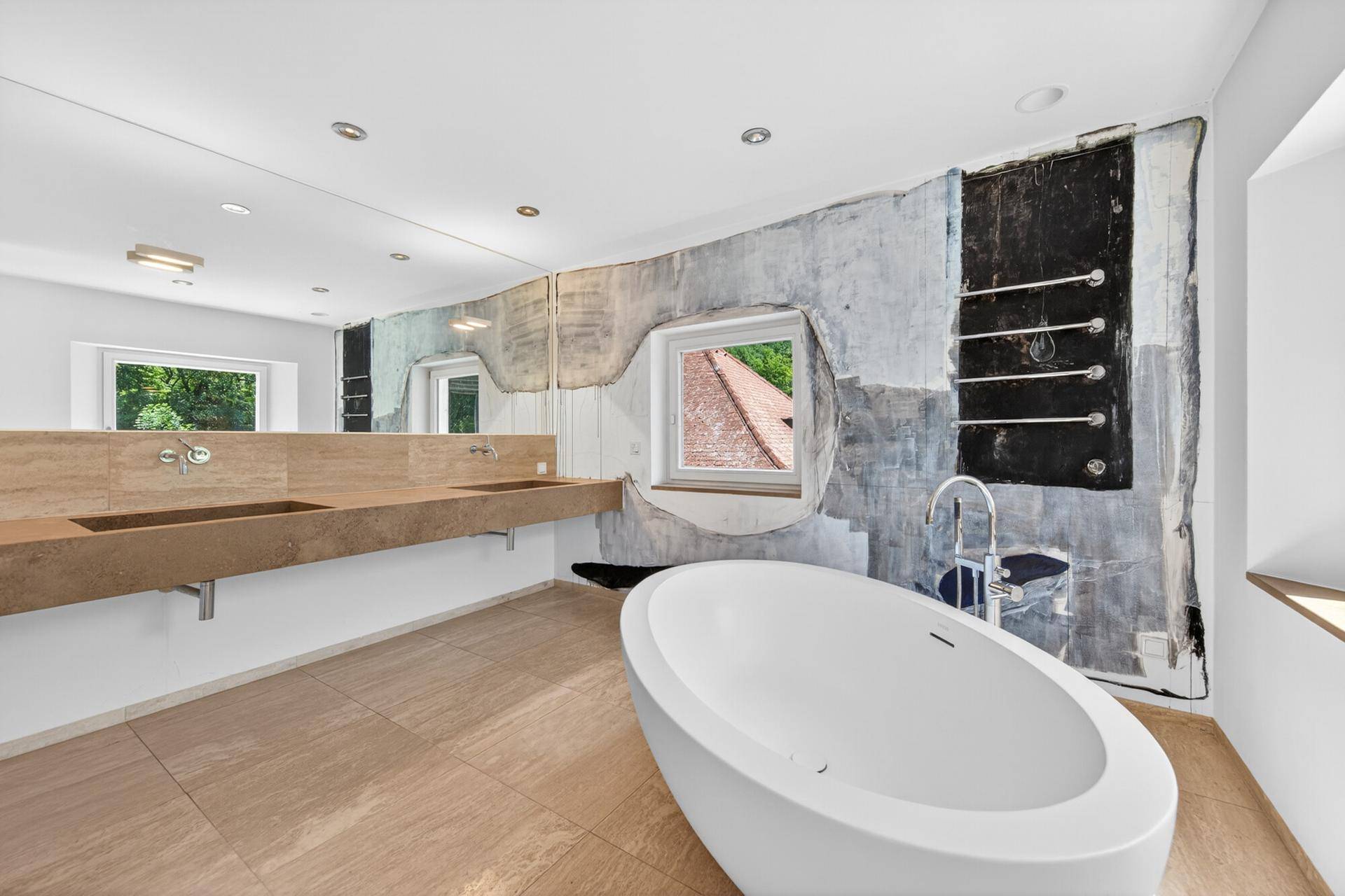 Luxuriöses Badezimmer mit freistehender Badewanne, Doppelwaschbecken und künstlerischer Wandgestaltung.