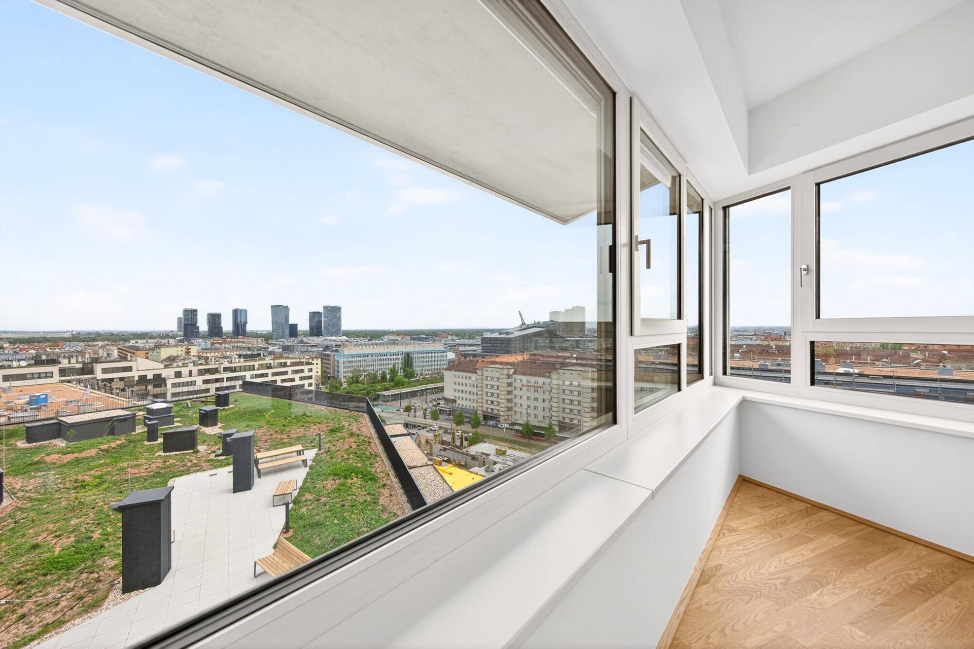 Raum mit großen Fenstern, die einen weiten Blick über die Stadt und die Umgebung bieten.
