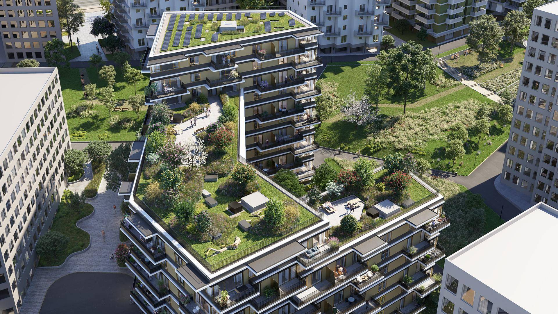 Luftaufnahme einer modernen Wohnanlage mit ausgedehnten begrünten Dächern und Photovoltaikanlage.