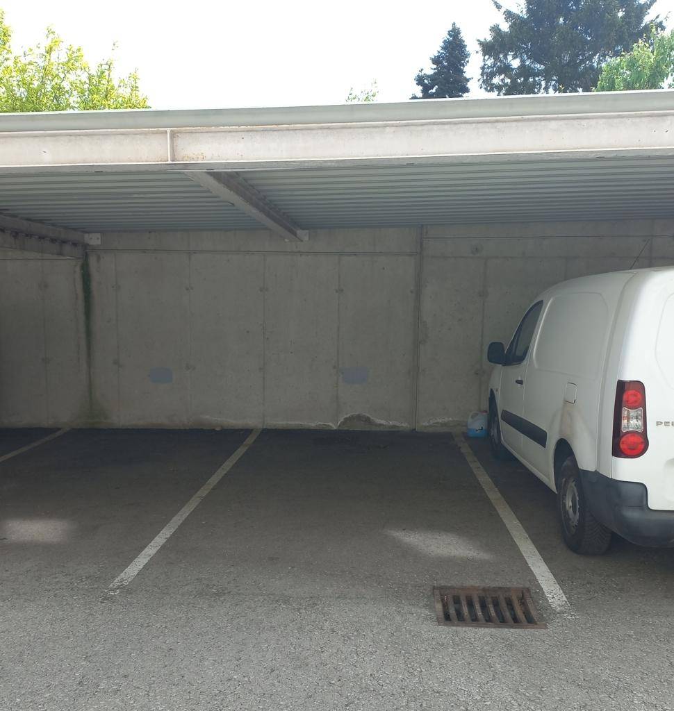 Überdachter Außenparkplatz mit einem geparkten Lieferwagen, bietet Schutz vor Witterung.