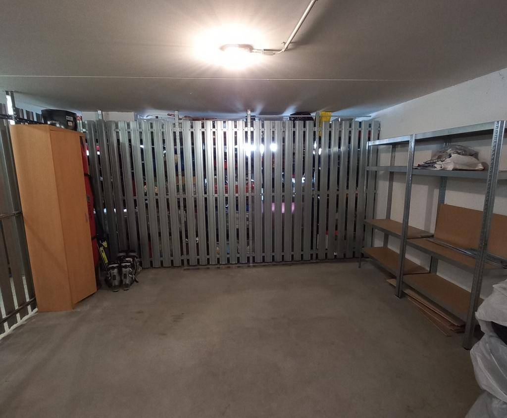Geräumiger Abstellraum mit Metallregalen und einem Holzschrank, ideal für Lagerzwecke.