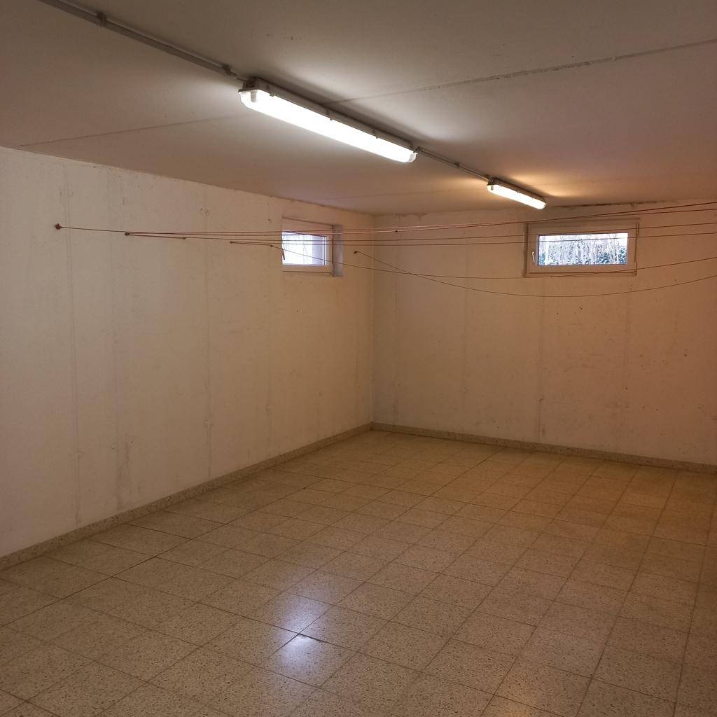Heller Kellerraum mit Fliesenboden und kleinen Fenstern, vielseitig nutzbar als Lagerfläche.