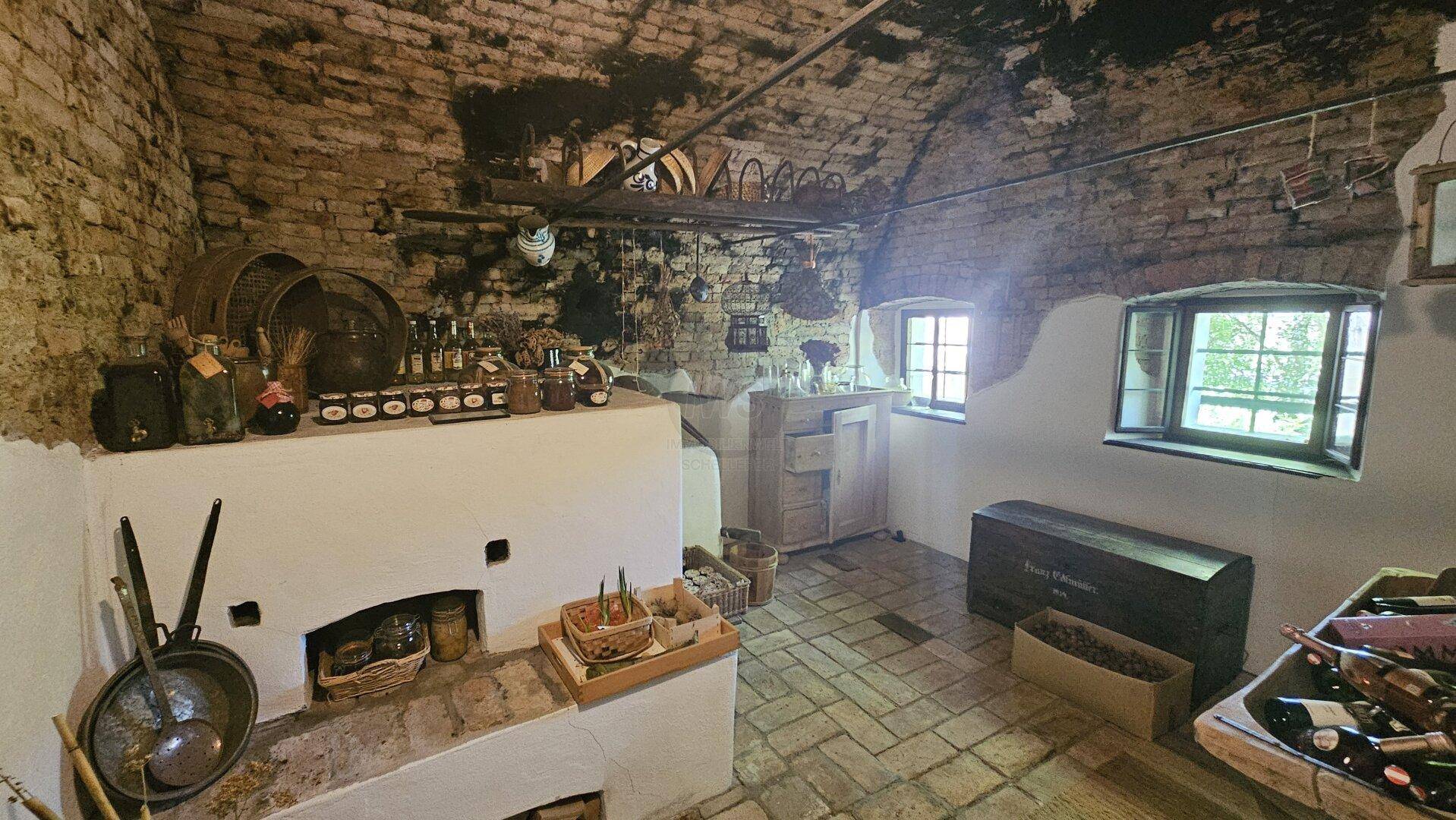 Historische Rauchküche oder Vorratsraum im Keller mit Gewölbedecke und Ziegelwänden.