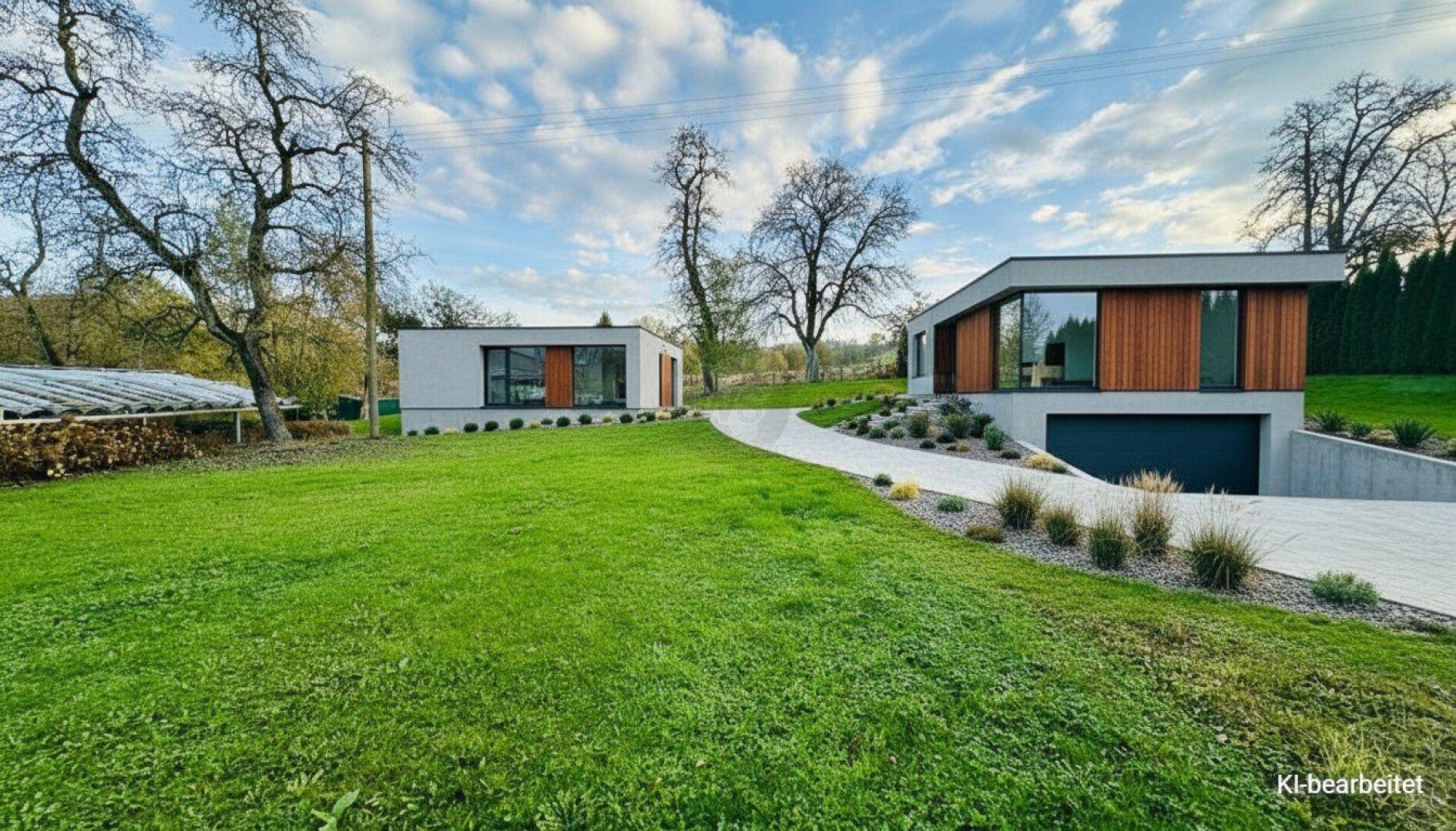 Moderne Häuser mit Holzverkleidung, integrierter Garage und weitläufiger Grünfläche.