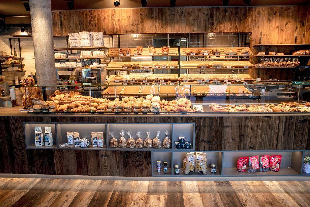 Reichhaltige Auswahl an Backwaren in einer Bäckerei mit rustikalem Holzdesign.
