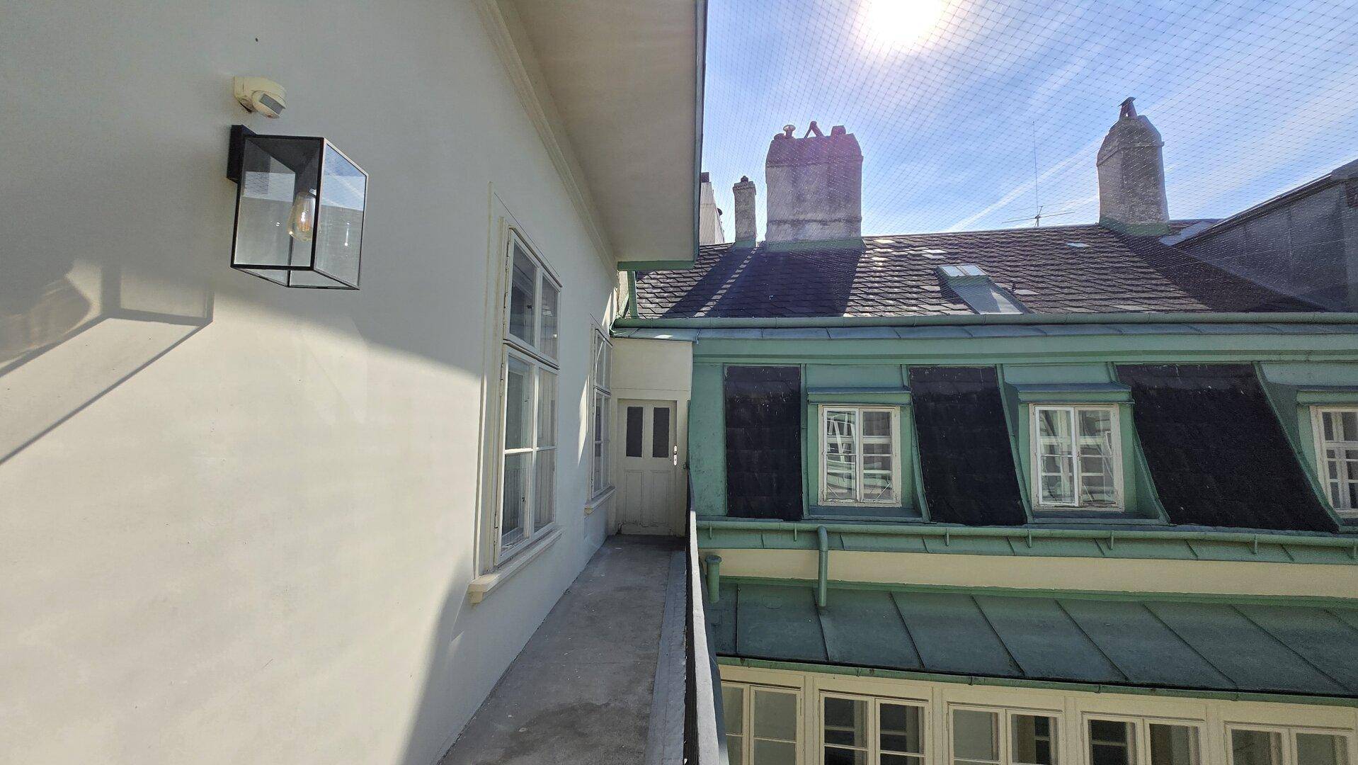 Sonniger Außenbereich mit Blick auf die Dächer und historische Gebäude.