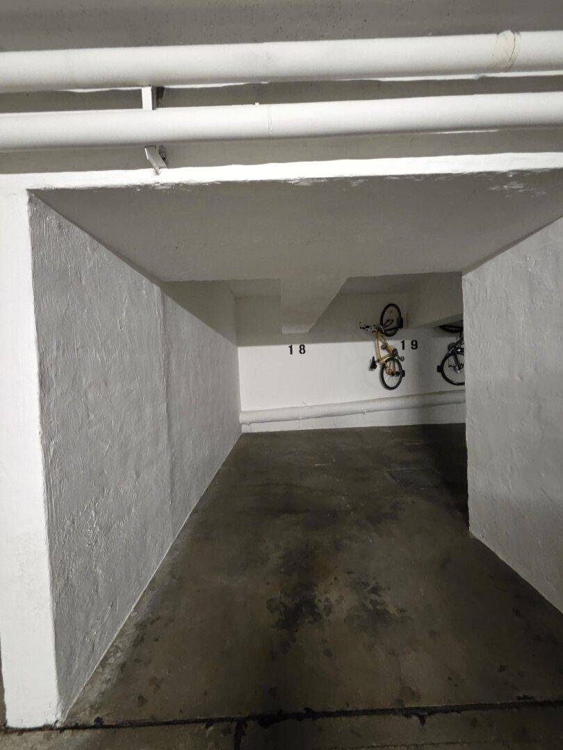 Fahrradraum im Keller mit Betonboden und Fahrrädern an der Wand.