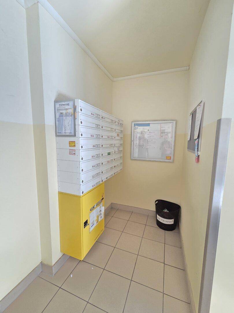 Eingangsbereich mit Briefkästen und Fliesenboden, funktional und hell.