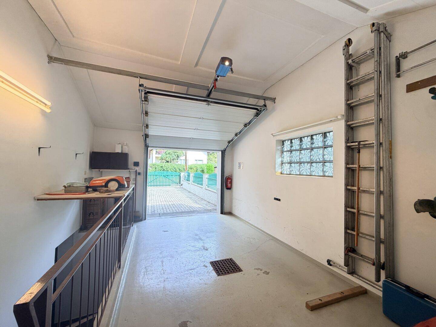 Geräumige Garage mit automatischem Sektionaltor und direktem Zugang zur Auffahrt.