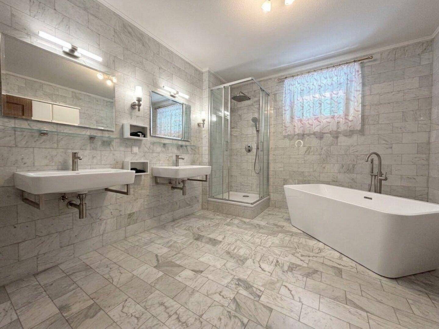 Luxuriöses Badezimmer mit freistehender Badewanne, moderner Dusche und Doppelwaschbecken.