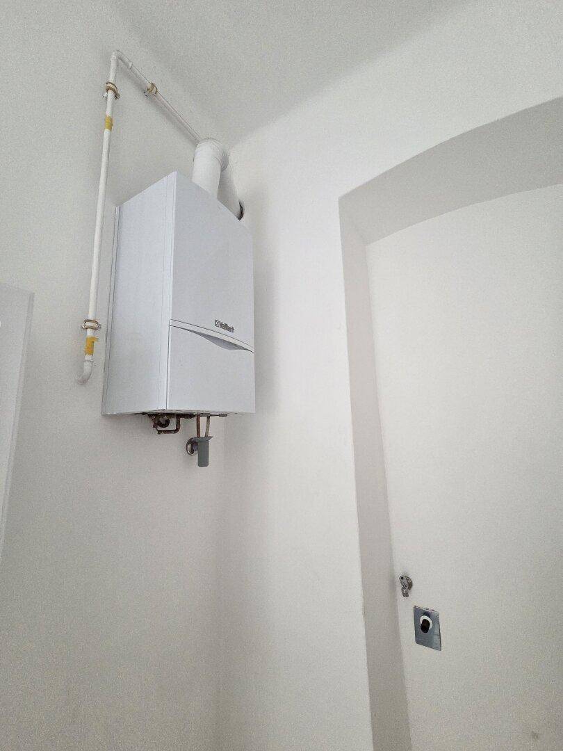 Gastherme an der Wand in einem kleinen, funktionalen Raum installiert.
