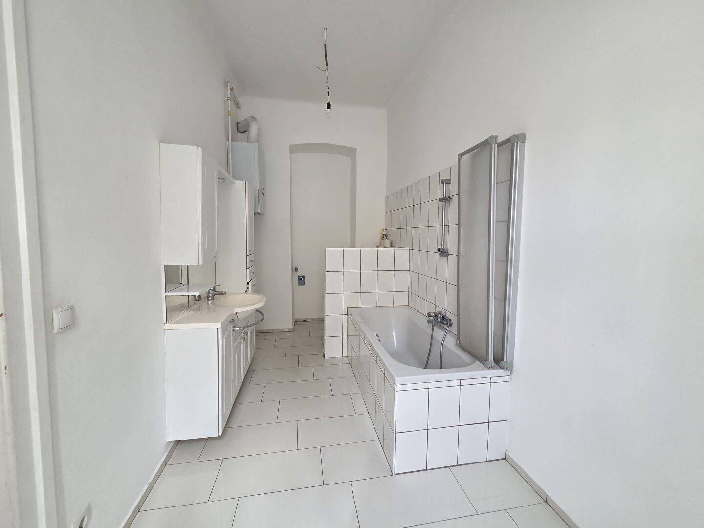 Geräumiges Badezimmer mit Badewanne und Waschbecken, bereit zur individuellen Gestaltung.