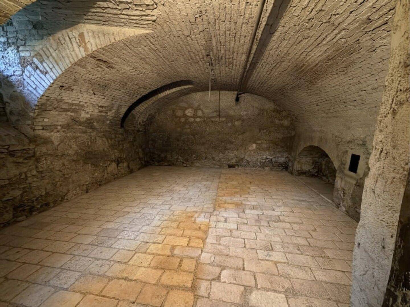 Historischer Gewölbekeller mit Ziegeldecken und Steinboden, ideal als Weinlager.