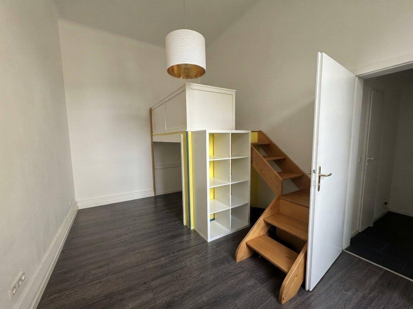 Kinderzimmer mit Hochbett und integriertem Regal, ideal für kleine Räume.