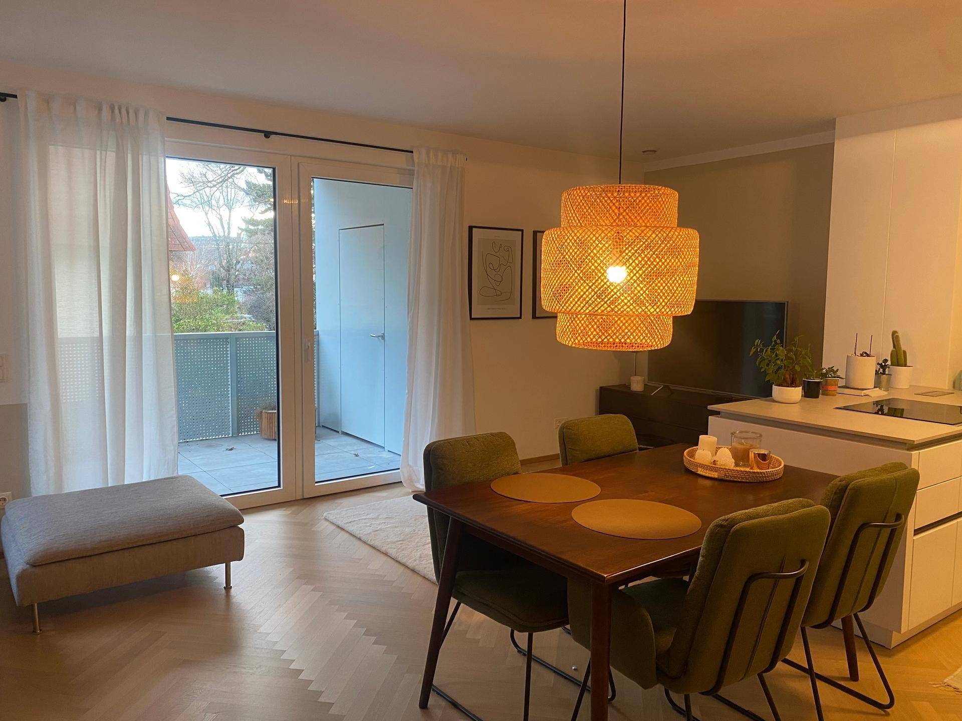 Lichtdurchfluteter Wohnbereich mit Zugang zum Balkon und modernem Parkettboden.