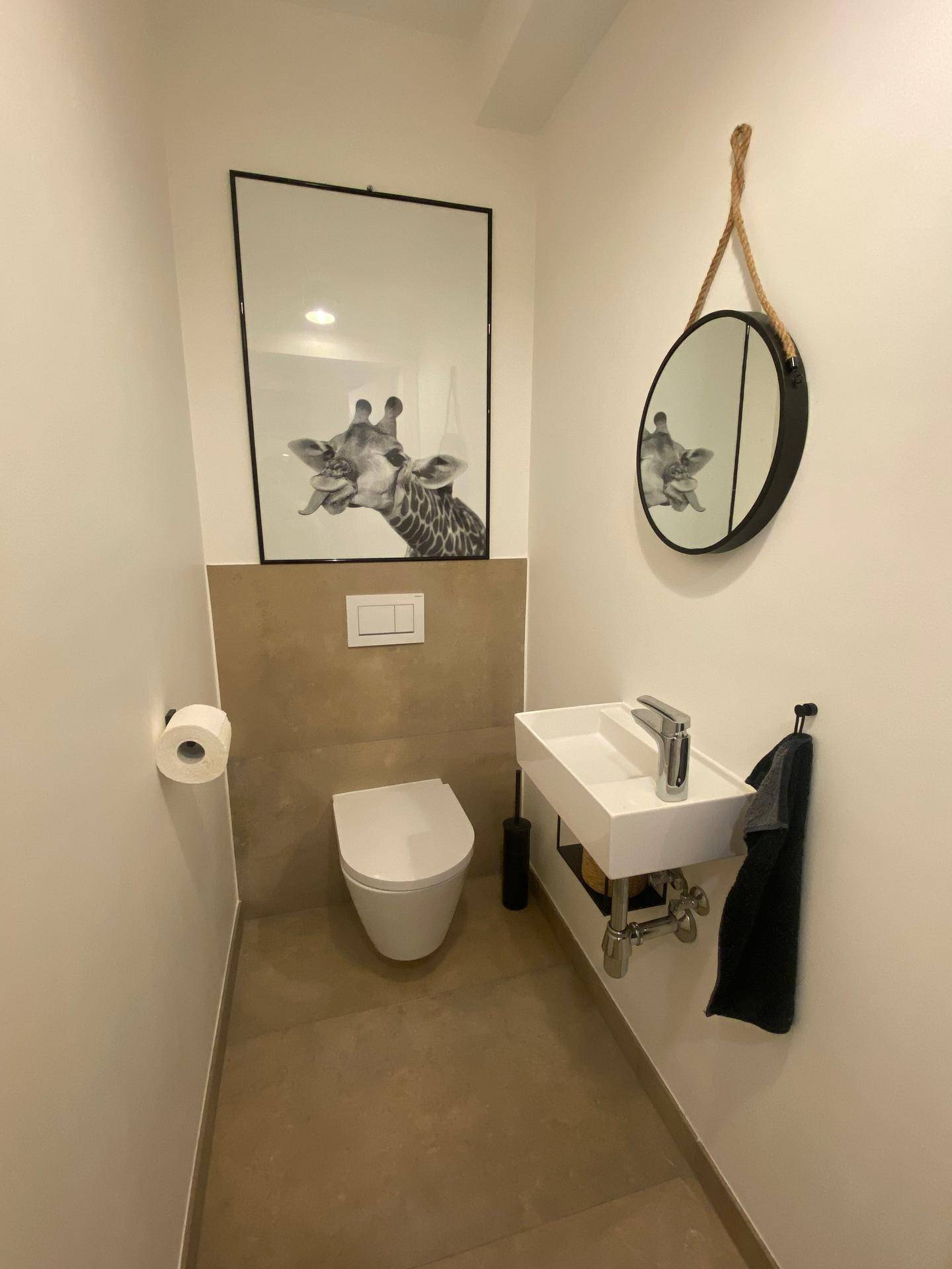 Modernes Gäste-WC mit Wand-WC, kleinem Waschbecken und stilvoller Dekoration.