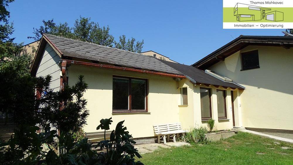 Seitenansicht des Hauses mit Rasenfläche und einem kleinen Gartenbereich.