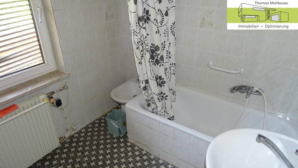 Badezimmer mit Badewanne, Duschvorhang und Fenster.
