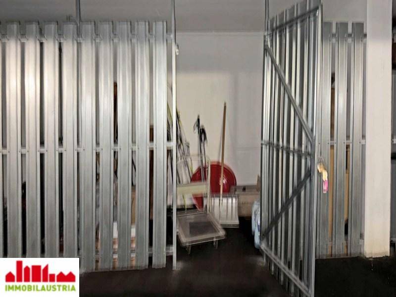 Abgetrennter Lagerraum in der Tiefgarage mit Metalltür und Stauraum.