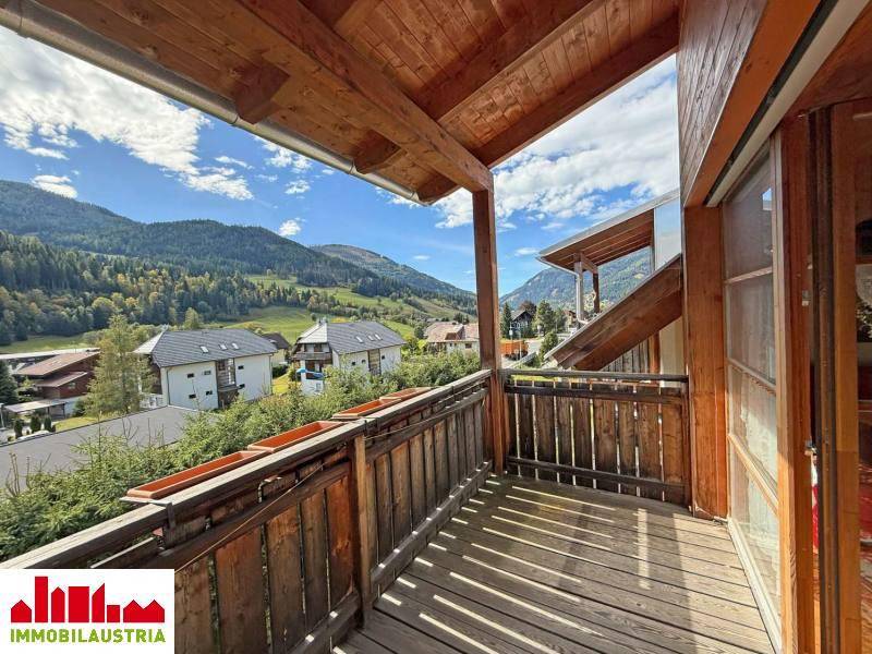 Holzbalkon mit Bergblick und ländlicher Umgebung, ideal für entspannte Stunden im Freien.