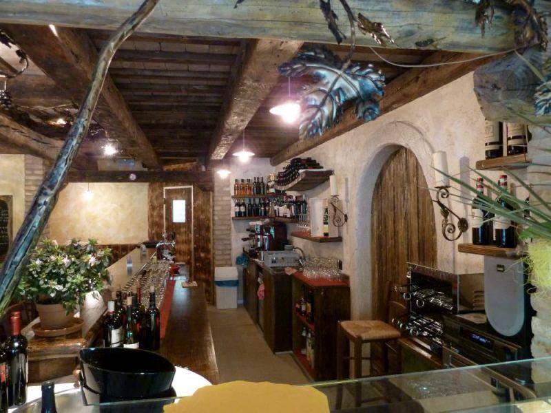 Detailansicht der Bar mit Kaffeemaschinen, Gläsern und Weinflaschen, unter rustikalen Holzbalken.