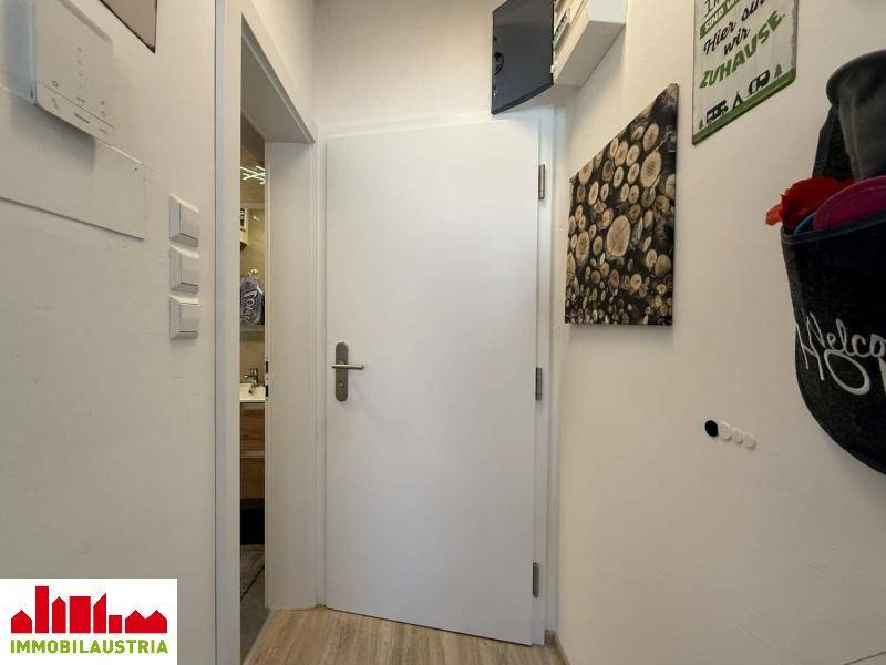 Heller Eingangsbereich mit Holzboden und Zugang zu den weiteren Räumen der Wohnung.
