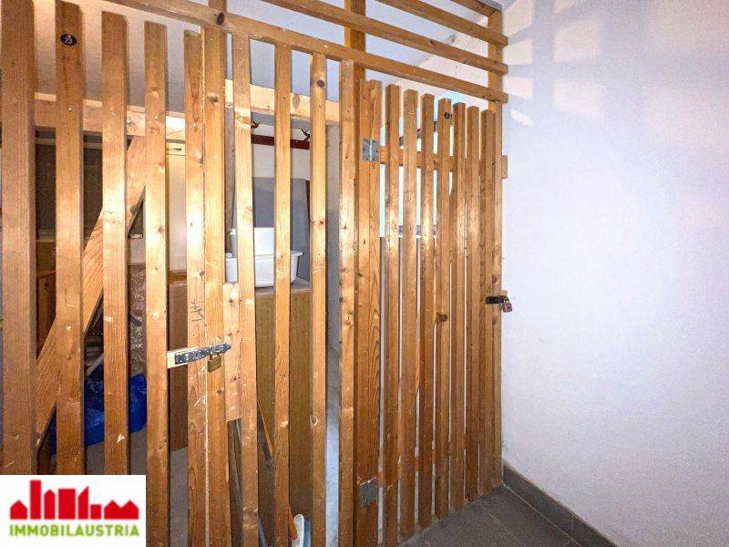Abgetrennte Lagerabteile aus Holz, ideal für zusätzlichen Stauraum im Kellerbereich.