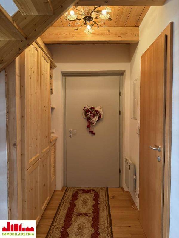 Eingangsbereich mit Holzschränken, Holzboden und einer schlichten Tür.